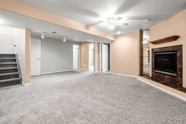 465 W Palmer Lake Dr, Pueblo West, CO 81007 - unfurnished living room featuring carpet, stairs, rail lighting, a fireplace, and baseboards