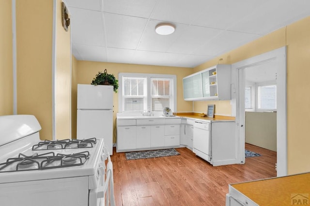 710 Wilson Ave, Pueblo, CO 81004 - kitchen featuring white appliances, light wood-style flooring, light countertops, and white cabinets