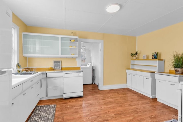 710 Wilson Ave, Pueblo, CO 81004 - kitchen with dishwasher, washer / clothes dryer, open shelves, light wood-type flooring, and white cabinets