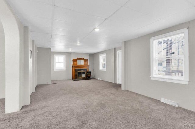 710 Wilson Ave, Pueblo, CO 81004 - unfurnished living room with carpet floors, a brick fireplace, and arched walkways