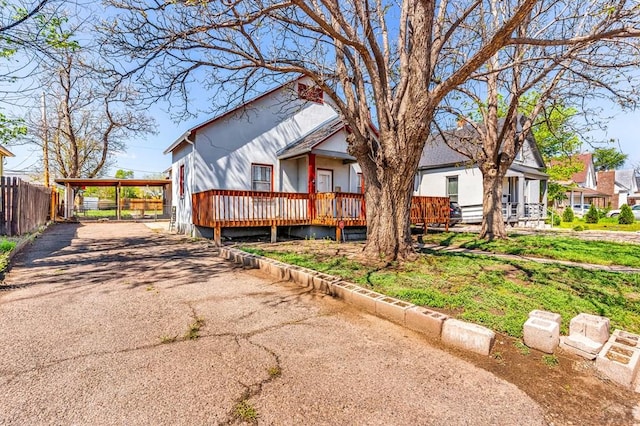 710 Wilson Ave, Pueblo, CO 81004 - rear view of property with fence, asphalt driveway, a wooden deck, and a carport