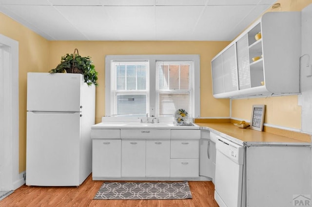 710 Wilson Ave, Pueblo, CO 81004 - kitchen with white appliances, light countertops, light wood-style floors, white cabinets, and open shelves