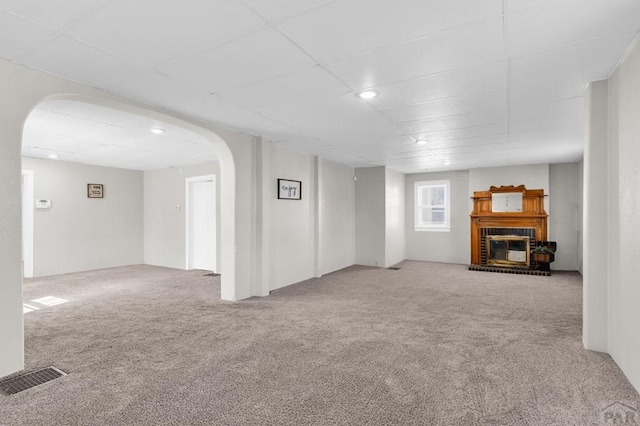 710 Wilson Ave, Pueblo, CO 81004 - unfurnished living room with arched walkways, carpet, a fireplace, and recessed lighting