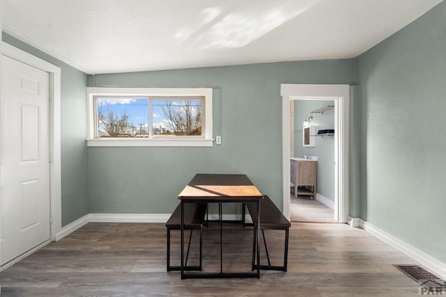 dining area with wood finished floors, visible vents, and baseboards