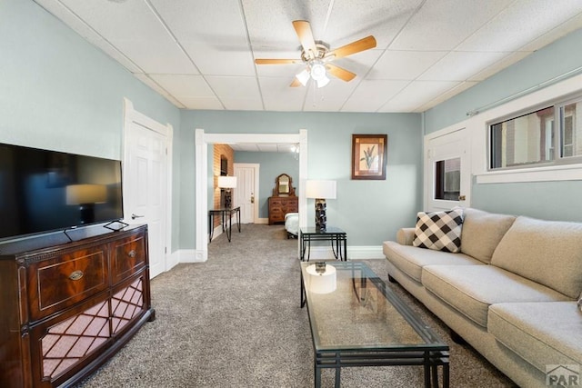 carpeted living area featuring a ceiling fan, a paneled ceiling, and baseboards