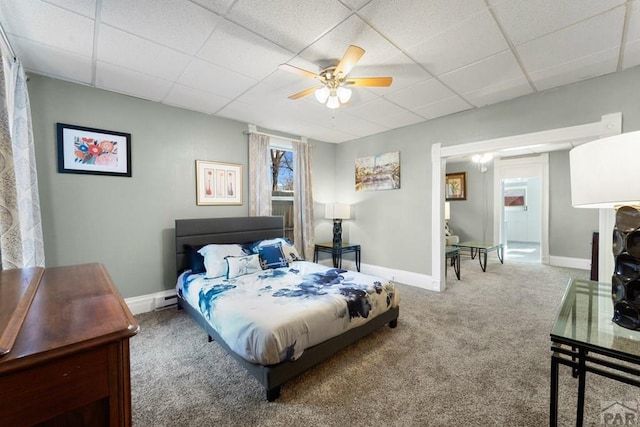 bedroom featuring ceiling fan, carpet floors, a drop ceiling, and baseboards