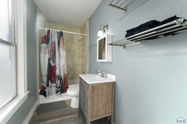 bathroom with toilet, shower / tub combo, wood finished floors, and vanity