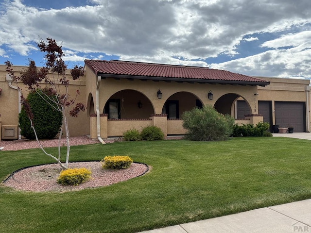 1318 Paseo Del Norte, Pueblo, CO 81008 - mediterranean / spanish house with an attached garage, a front lawn, stucco siding, a tiled roof, and driveway