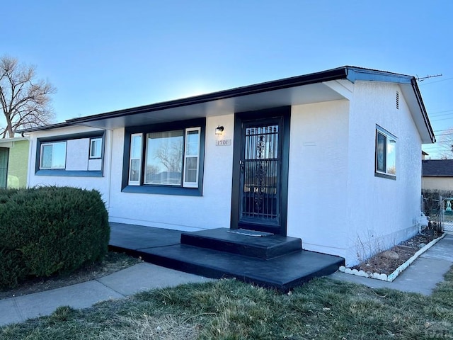 doorway to property featuring stucco siding