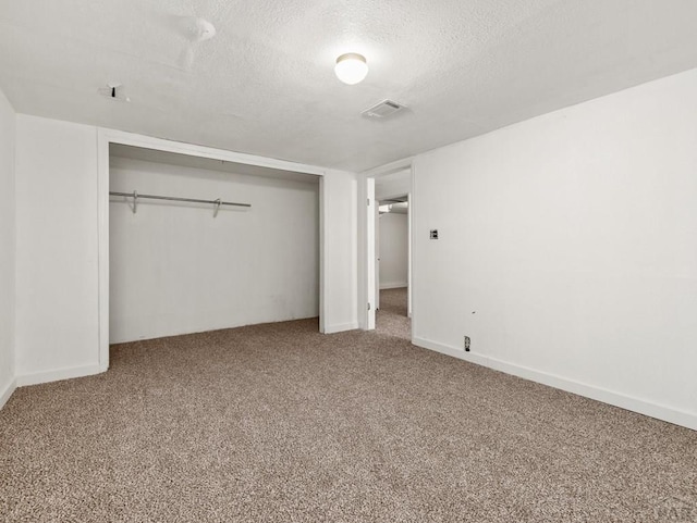 unfurnished bedroom with carpet floors, a closet, a textured ceiling, and baseboards