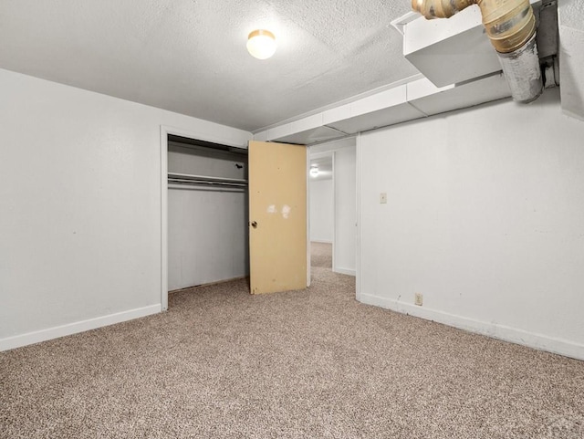 unfurnished bedroom featuring carpet floors, a closet, a textured ceiling, and baseboards