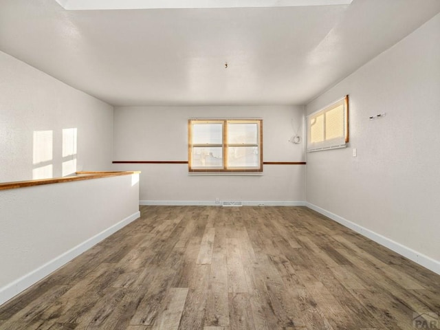 unfurnished room featuring baseboards and wood finished floors