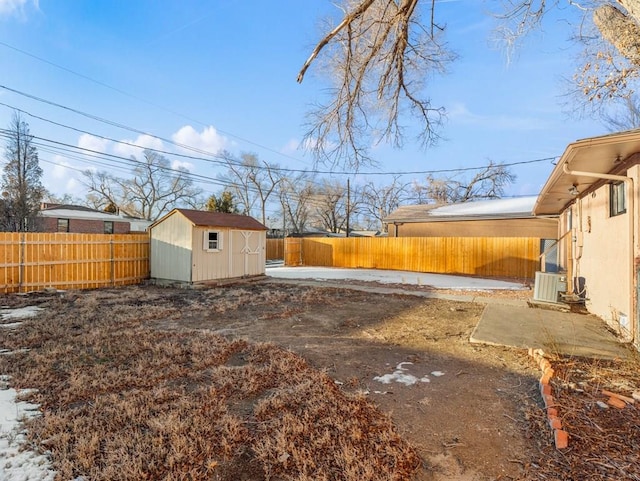 view of yard featuring a storage shed, a patio area, an outdoor structure, and a fenced backyard