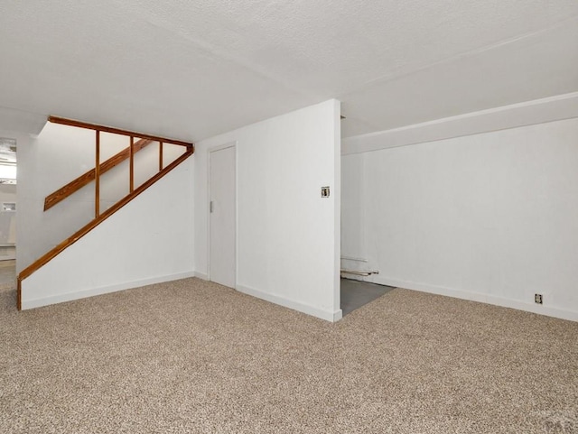 interior space with carpet flooring, a textured ceiling, and baseboards