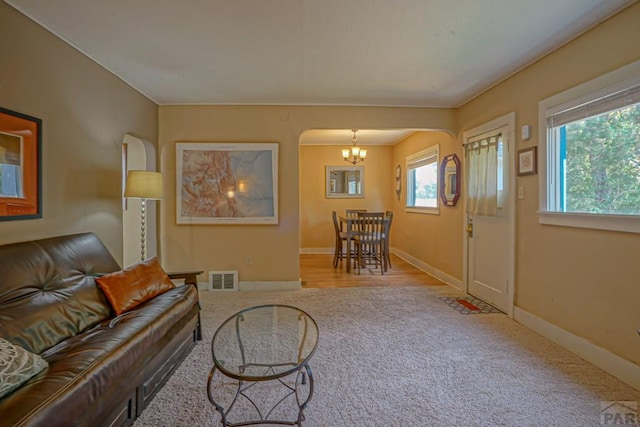 328 Colorado Ave, Walsenburg, CO 81089 - living room with a healthy amount of sunlight, a notable chandelier, arched walkways, and visible vents