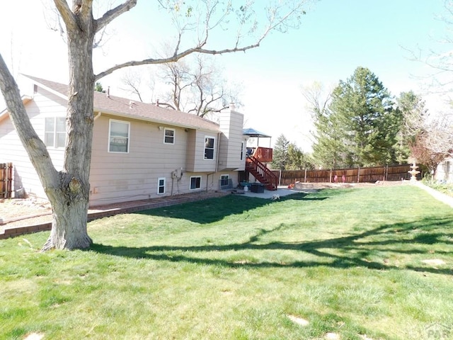 6 Ironweed Dr, Pueblo, CO 81001 - back of house with a chimney, fence, a yard, and stairs