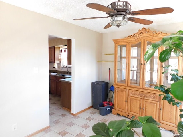 6 Ironweed Dr, Pueblo, CO 81001 - interior space featuring a textured ceiling, a ceiling fan, baseboards, and a sink