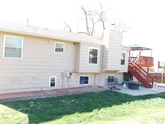 6 Ironweed Dr, Pueblo, CO 81001 - back of house featuring a chimney, a deck, stairway, a patio, and a lawn