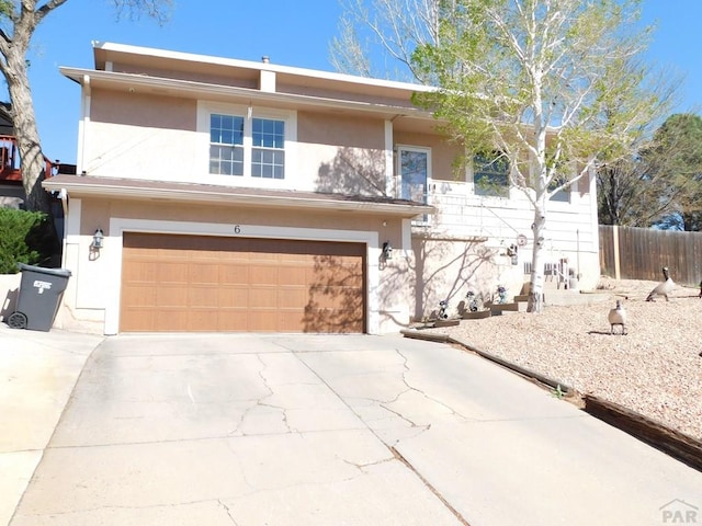 6 Ironweed Dr, Pueblo, CO 81001 - view of front of property featuring a garage, fence, stucco siding, and driveway