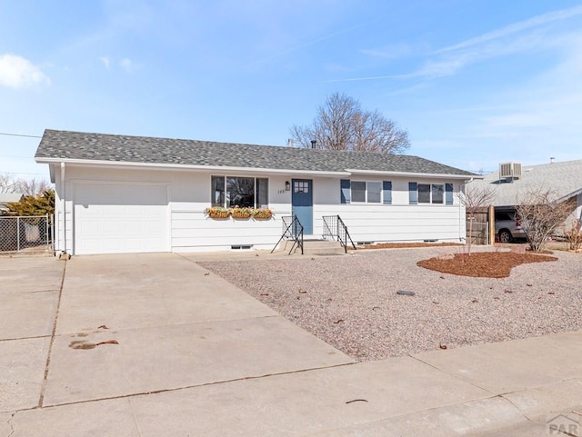 single story home featuring concrete driveway, roof with shingles, an attached garage, fence, and cooling unit