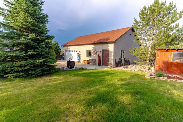 rear view of house featuring a garage and a lawn