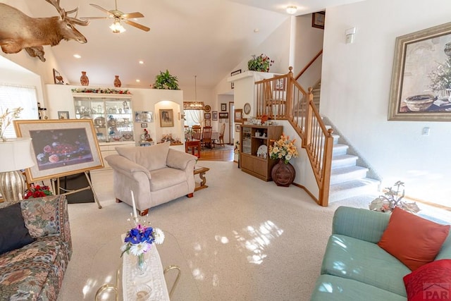 living room with arched walkways, high vaulted ceiling, carpet floors, a ceiling fan, and stairs