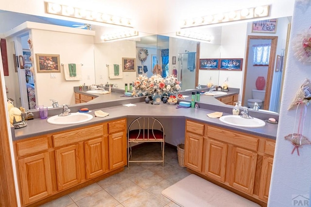 full bathroom with toilet, tile patterned flooring, and vanity