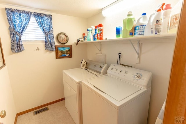 laundry area with laundry area, washing machine and dryer, visible vents, and baseboards