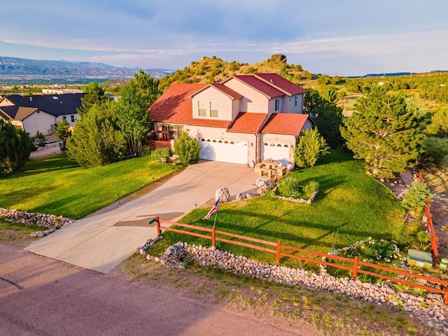 view of front of house with a garage, fence, concrete driveway, a residential view, and a front yard