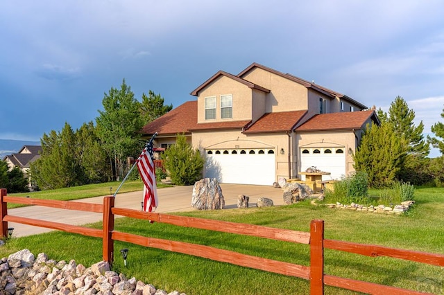 view of front facade with driveway, fence, a front lawn, and stucco siding