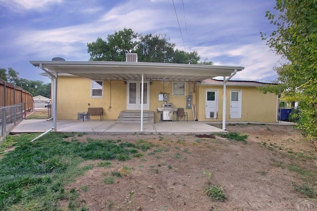 rear view of property featuring cooling unit, a patio area, fence, and stucco siding