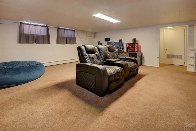 home theater room featuring light carpet, a baseboard heating unit, and visible vents