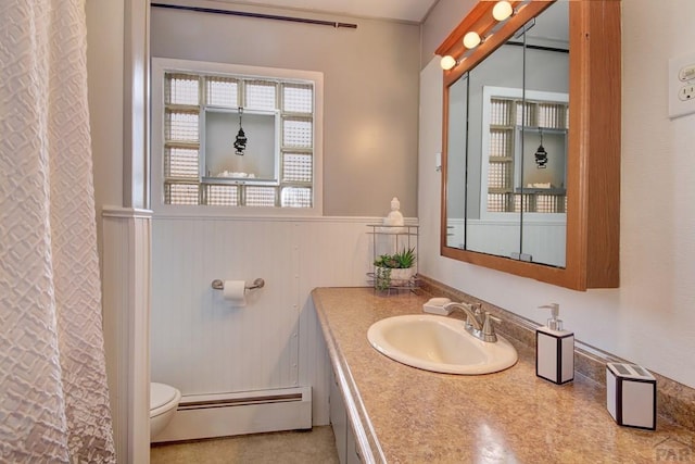 full bathroom with toilet, a wainscoted wall, curtained shower, vanity, and a baseboard heating unit