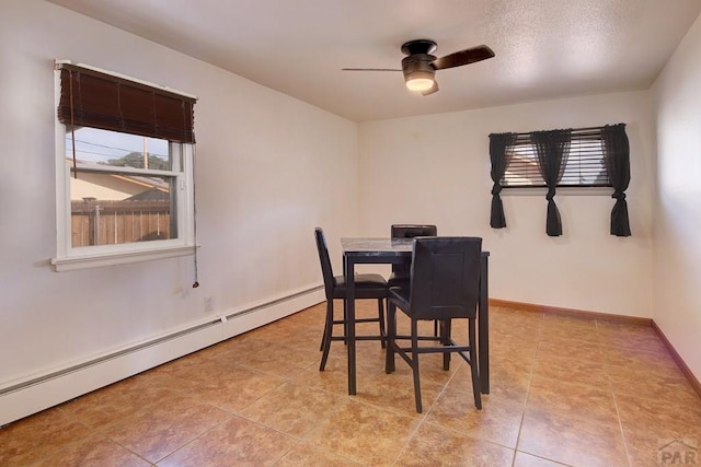 dining area featuring a baseboard heating unit, baseboards, a ceiling fan, and a healthy amount of sunlight