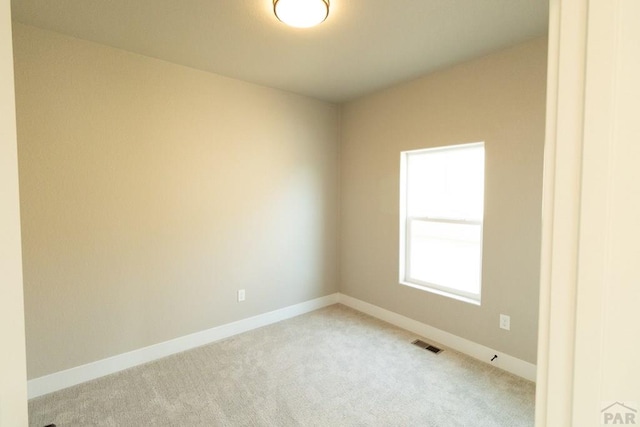 unfurnished room with light colored carpet, visible vents, and baseboards