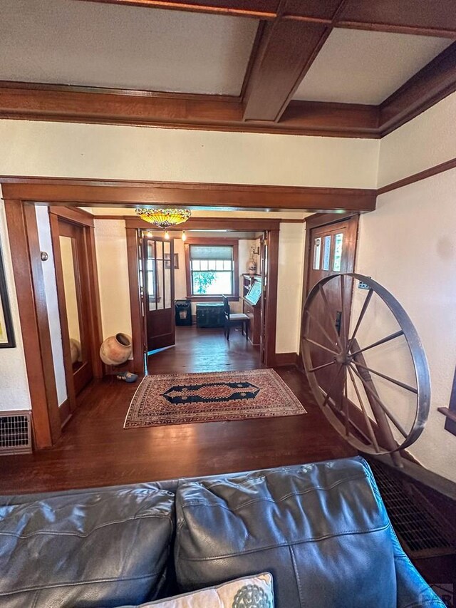 entrance foyer featuring dark wood-style flooring, beam ceiling, and baseboards