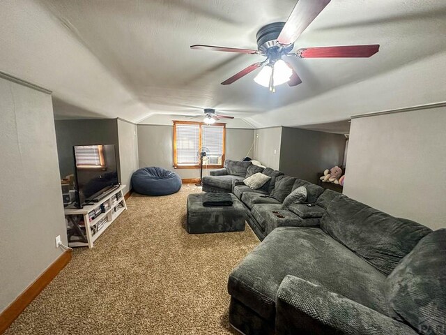 living room with lofted ceiling, ceiling fan, baseboards, and carpet flooring