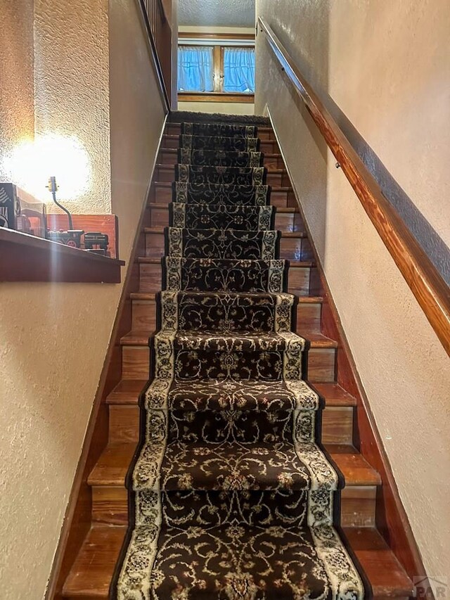 stairs featuring a textured wall