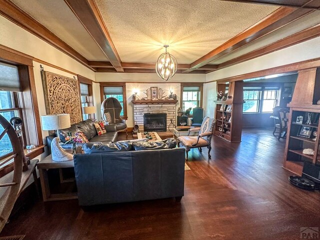 living area with a chandelier, dark wood finished floors, beam ceiling, and a fireplace