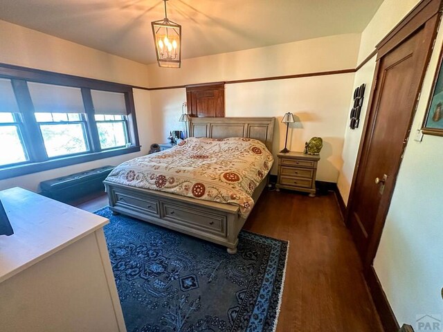 bedroom featuring dark wood-style flooring and baseboards