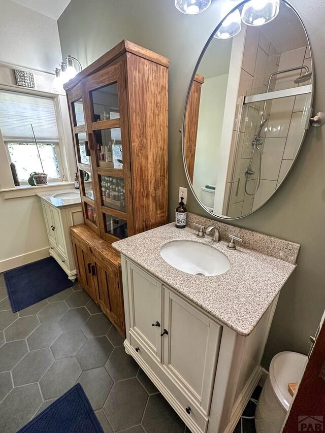 bathroom featuring a stall shower, vanity, toilet, and tile patterned floors