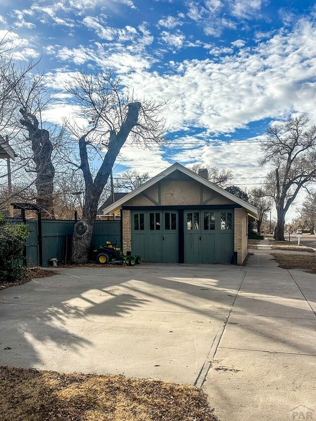 view of front of house with a garage, brick siding, and fence