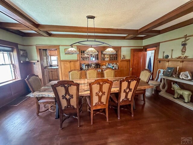 dining area with dark wood-style floors, wainscoting, coffered ceiling, and visible vents