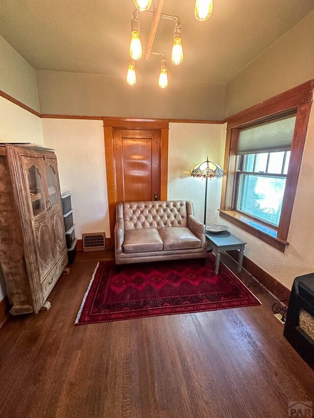 unfurnished room with baseboards, visible vents, and dark wood-style flooring