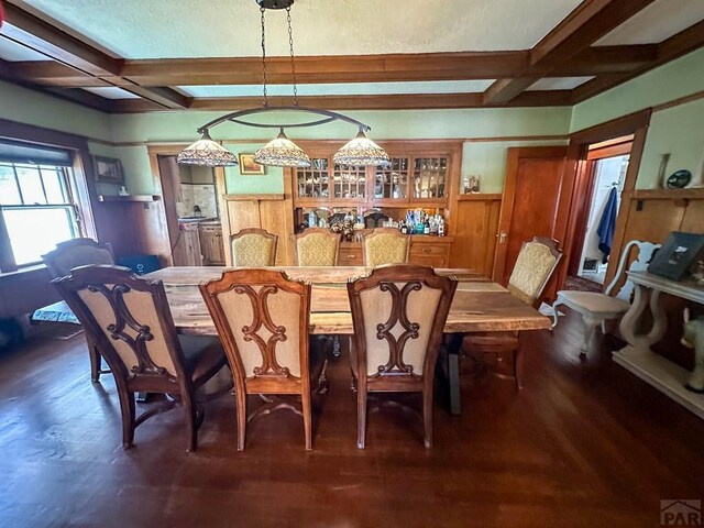 dining space with dark wood-style floors, beamed ceiling, and coffered ceiling