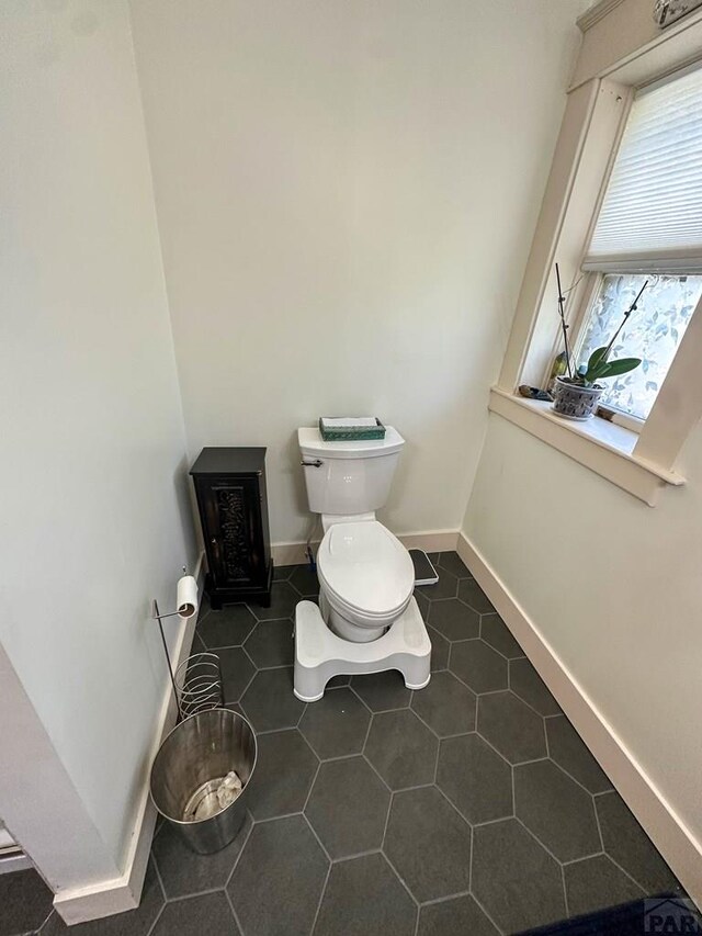 bathroom featuring baseboards, toilet, and tile patterned floors