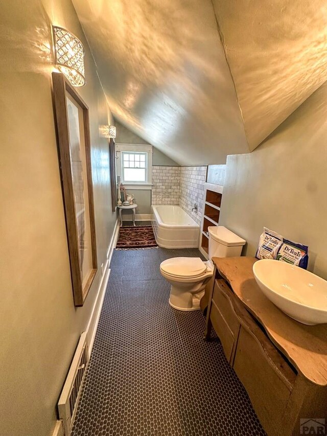 full bath with visible vents, toilet, vaulted ceiling, baseboards, and a bath