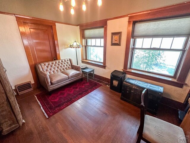 living room featuring dark wood-style floors, visible vents, and baseboards