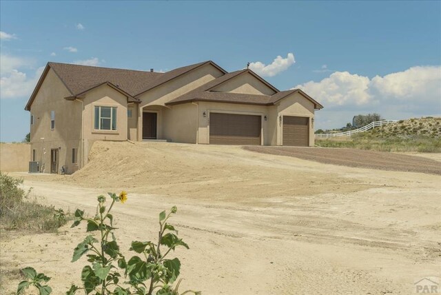 view of front of house featuring a garage, driveway, and stucco siding