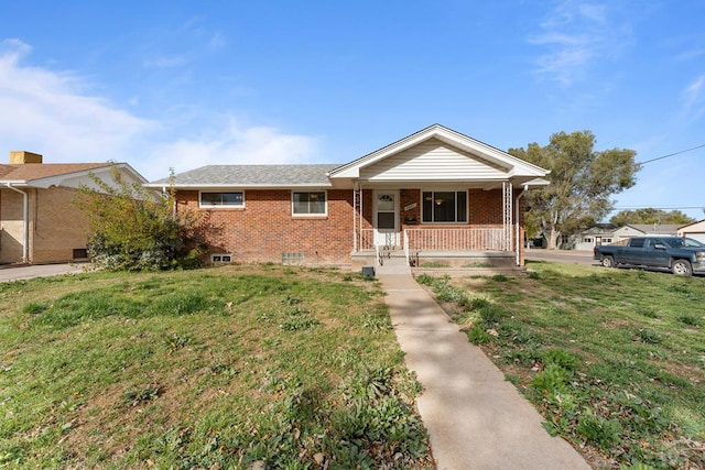 view of front of house with covered porch, crawl space, brick siding, and a front lawn